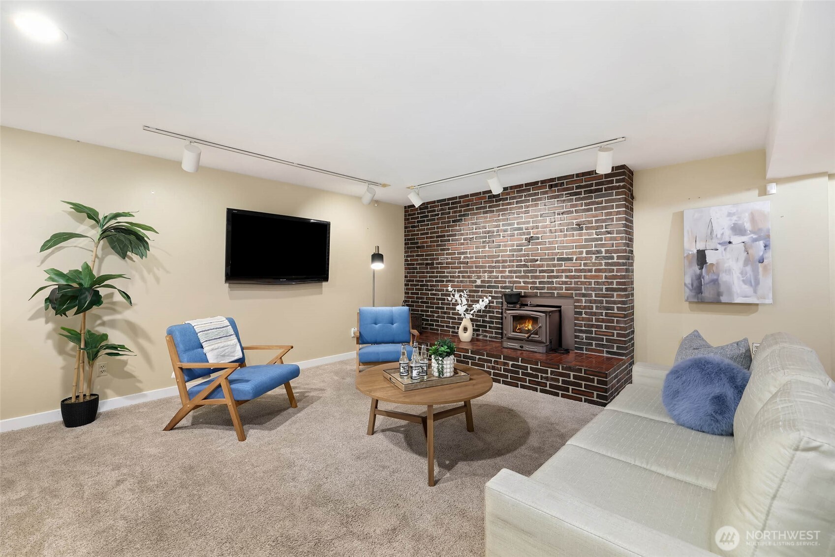 27239 208th Avenue Southeast Maple Valley, WA 98038 - Photo 23 of 40 a living room with furniture a flat screen tv and a fireplace