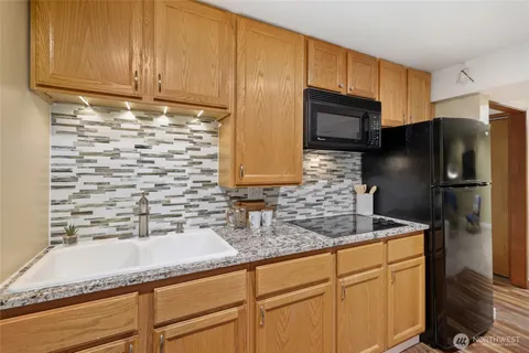a kitchen with granite countertop a sink stainless steel appliances and cabinets