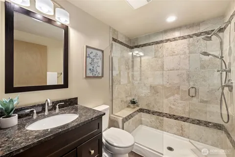 a bathroom with a sink vanity mirror bathtub and toilet