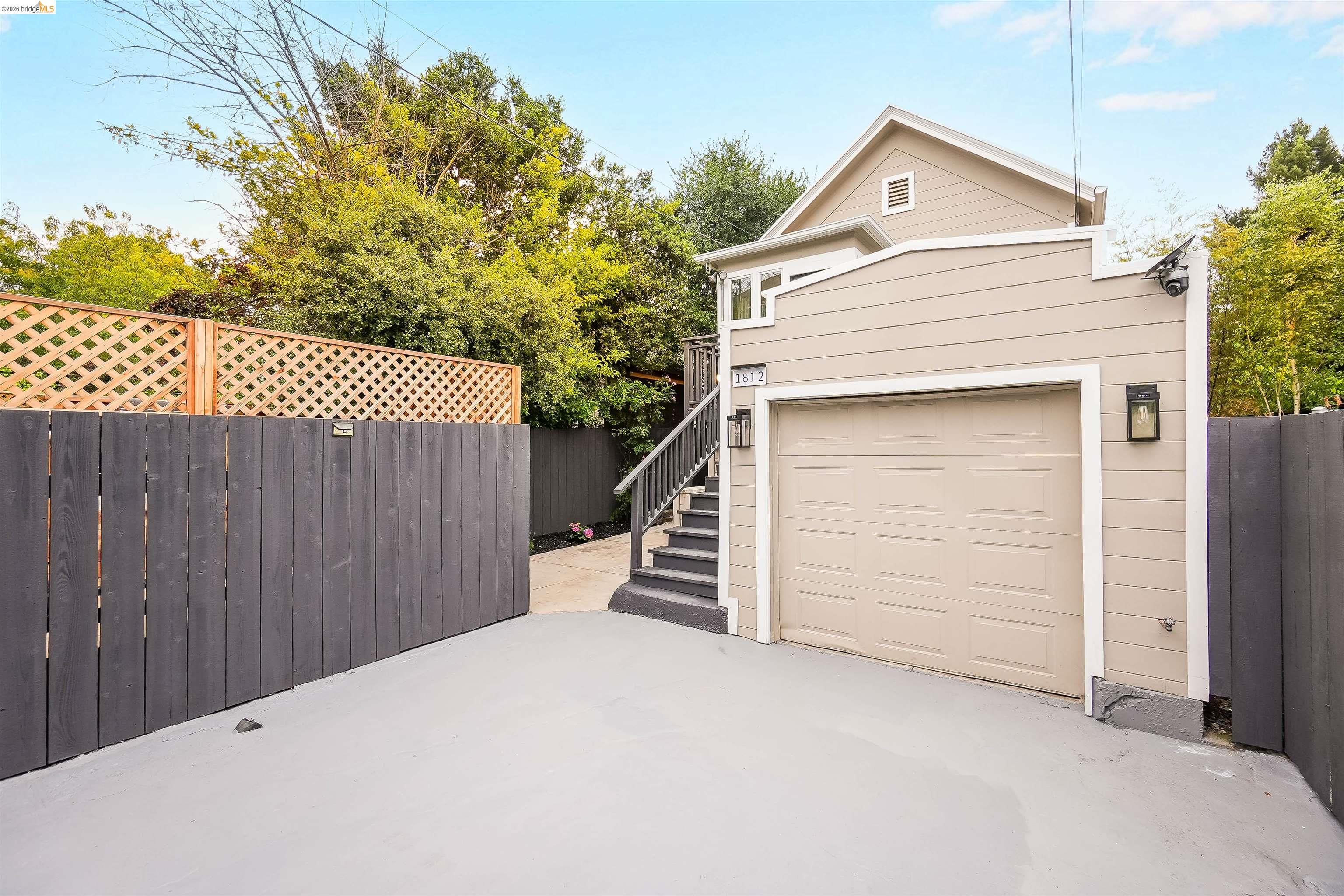 1812 Woolsey Street Berkeley, CA 94703 - Photo 3 of 48 Attached garage with a panel door, complemented by a light beige exterior with horizontal siding