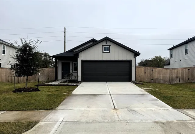 a front view of a house with a yard and trees