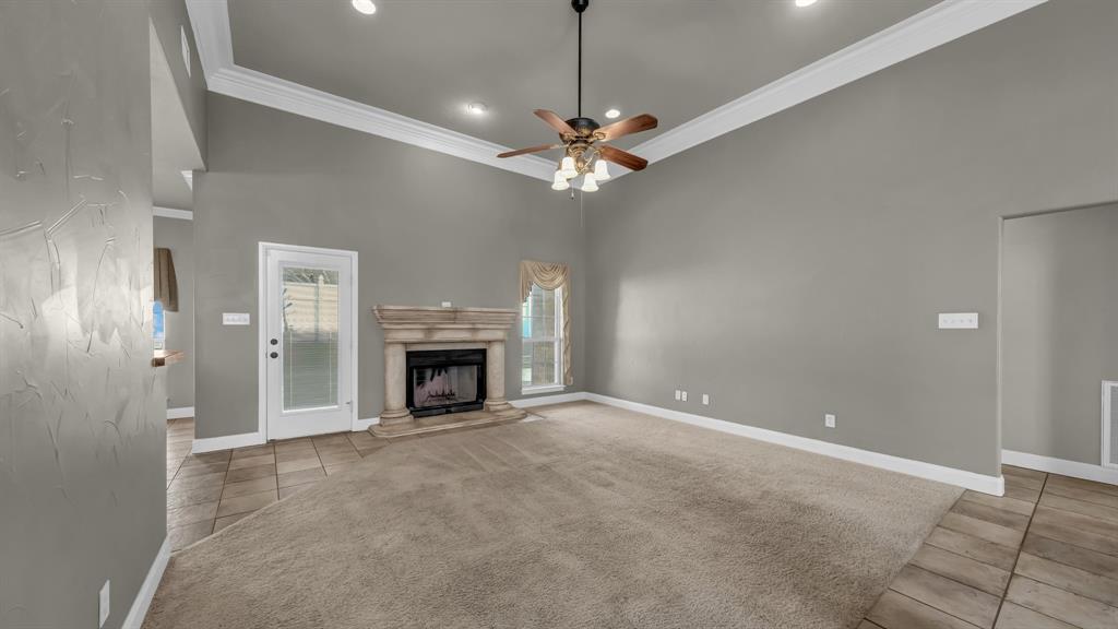 1106 Owl Street Decatur, TX 76234 - Photo 11 of 40 a view of a livingroom with a ceiling fan a fireplace and a chandelier