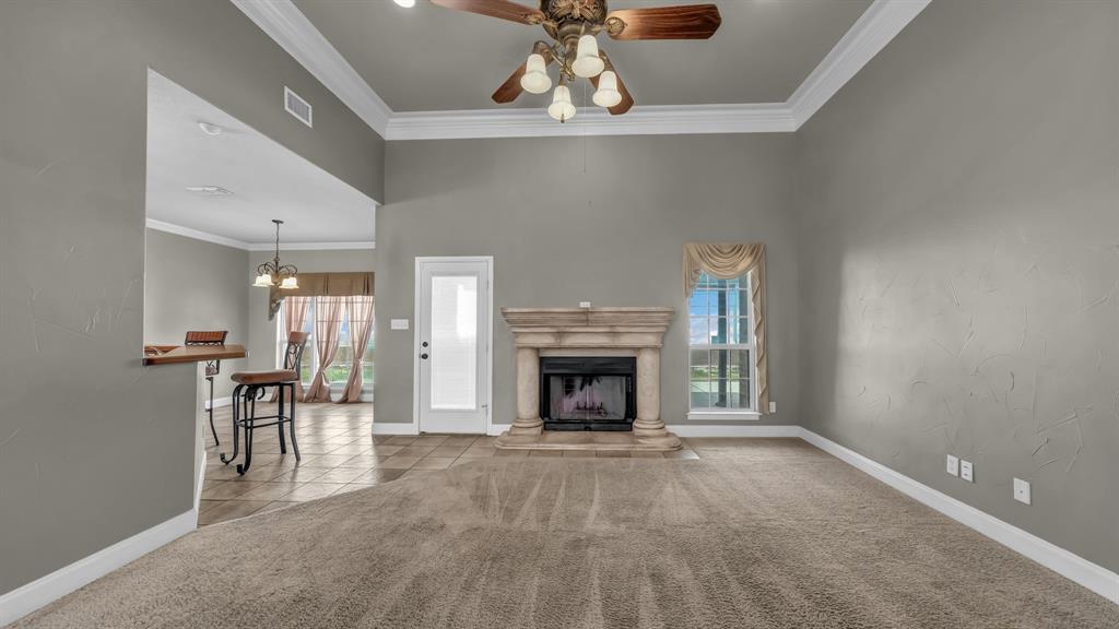 1106 Owl Street Decatur, TX 76234 - Photo 12 of 40 a view of a livingroom with a fireplace a chandelier and windows