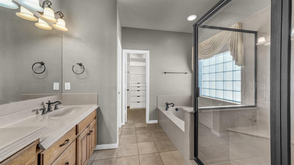 1106 Owl Street Decatur, TX 76234 - Photo 29 of 40 a bathroom with a double vanity sink a mirror and a bathtub