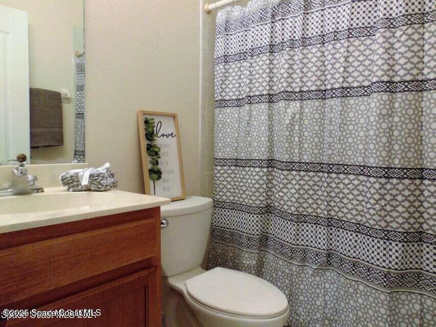 2087 Hidden Grove Lane, Unit 105B Merritt Island, FL 32953 - Photo 13 of 22 a white toilet sitting next to a bathroom sink