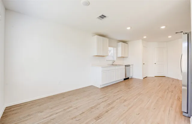 a view of a kitchen with a sink and a refrigerator