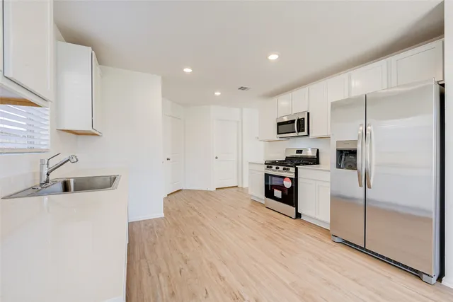 a kitchen with granite countertop a refrigerator and a sink