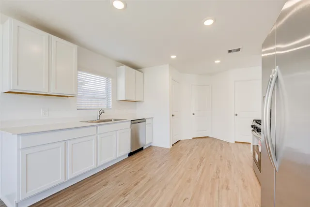 a kitchen with a sink window and cabinets