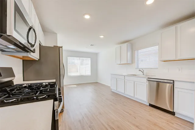 a kitchen with stainless steel appliances granite countertop a stove and a refrigerator