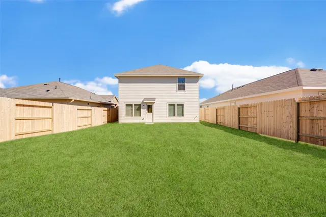 a view of a white house in front of a big yard