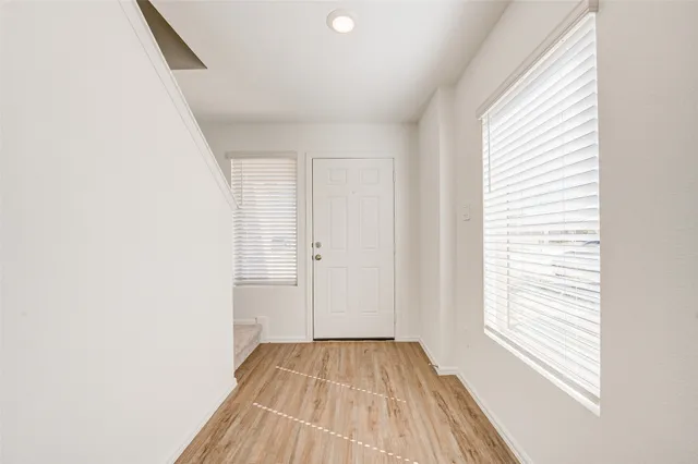 a view of a room with wooden floor and a window