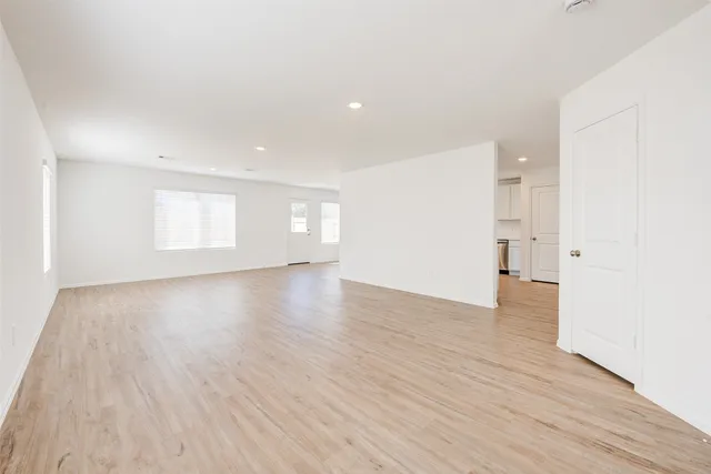 a view of empty room with wooden floor and windows