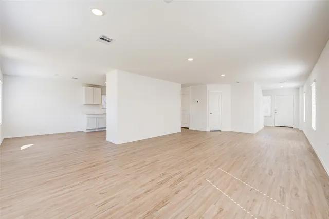 a view of empty room with wooden floor