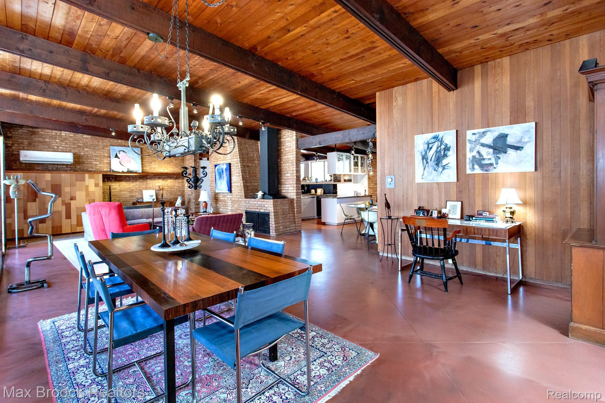 30875 Franklin Road Franklin, MI 48025 - Photo 19 of 86 Dining room featuring hanging lights, brick wall, wooden walls, finished concrete floors, and a wood ceiling with exposed beams
