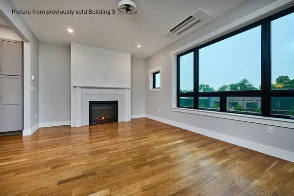 a view of an empty room with a fireplace and a floor to ceiling window