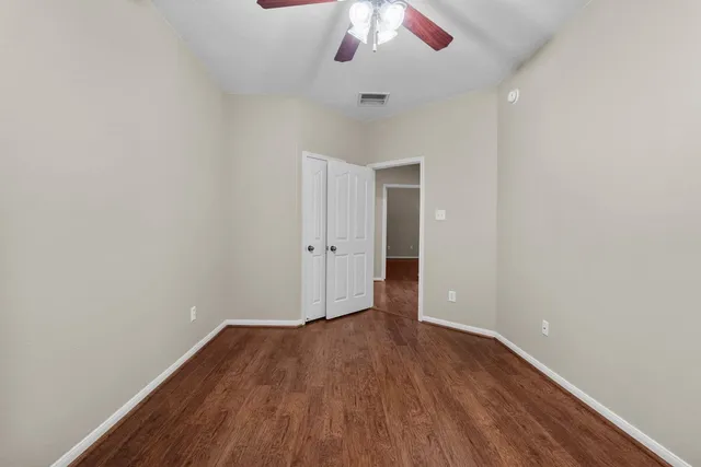 a view of an empty walk in closet and wooden floor