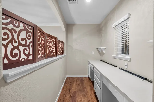 a view of a kitchen with wooden floor and a ceiling fan