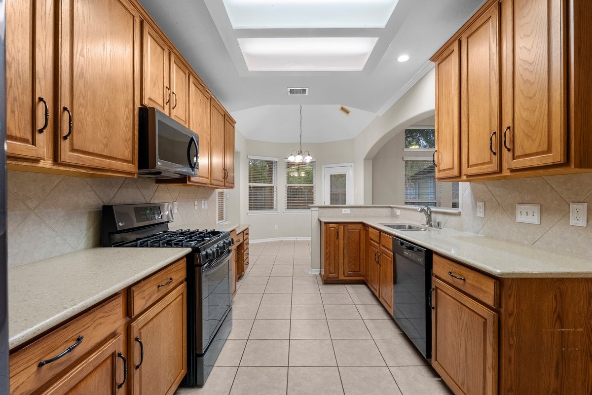 2231 Water Way Seabrook, TX 77586 - Photo 36 of 43 a kitchen with stainless steel appliances granite countertop a stove a sink and a microwave