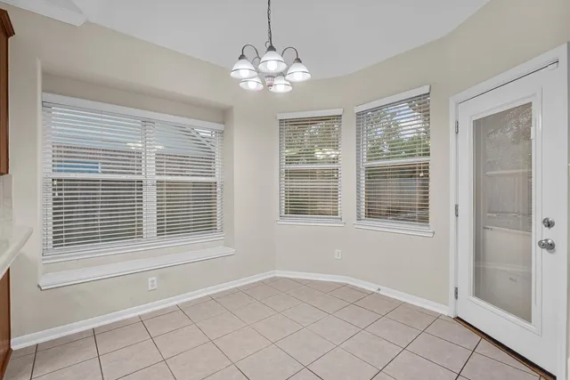 a view of a room with wooden floor and a chandelier fan