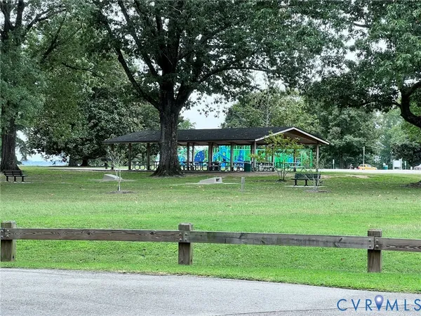a view of a lake with a yard and large trees