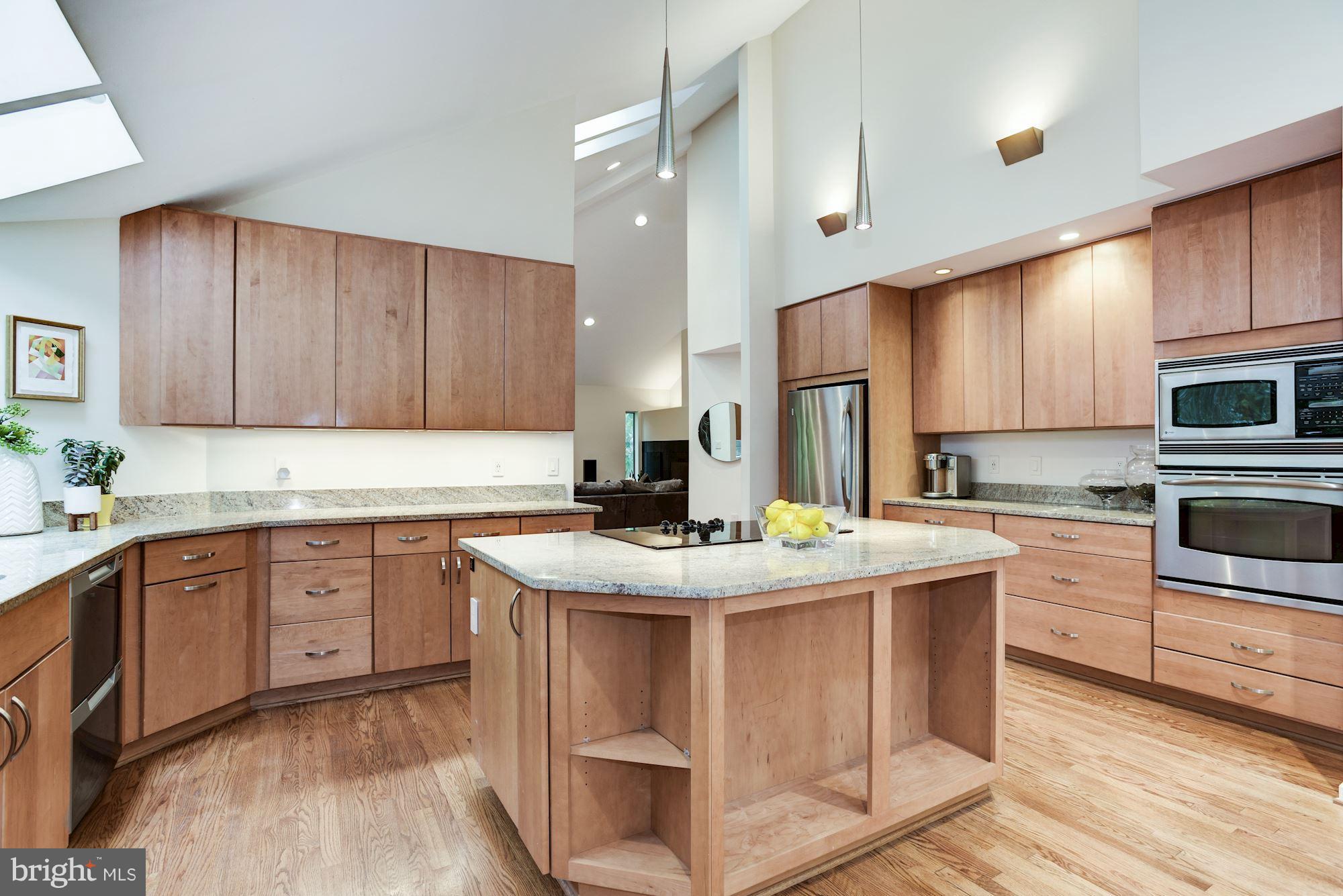 2119 Owls Cove Lane Reston, VA 20191 - Photo 9 of 30 a kitchen with kitchen island granite countertop a sink stove and wooden cabinets
