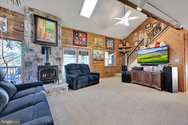 a living room with furniture a fireplace and a ceiling fan