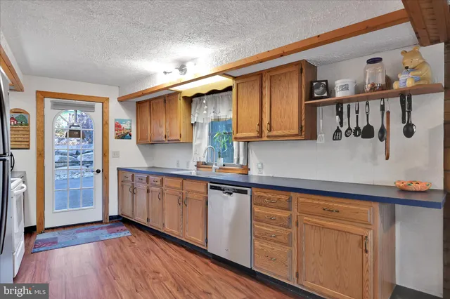 a kitchen with granite countertop white cabinets and wooden floor