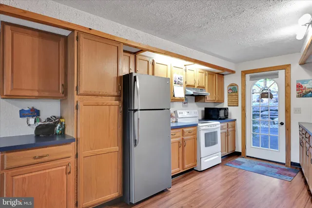 a kitchen with stainless steel appliances a refrigerator sink and cabinets