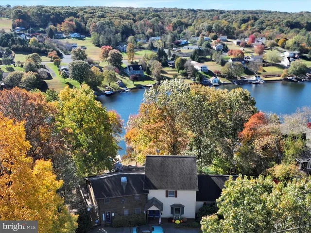 an aerial view of a house with a garden and lake view