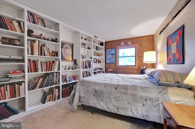 a bedroom with a bed and lamp on dresser