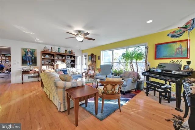 a living room with furniture a flat screen tv and a large window