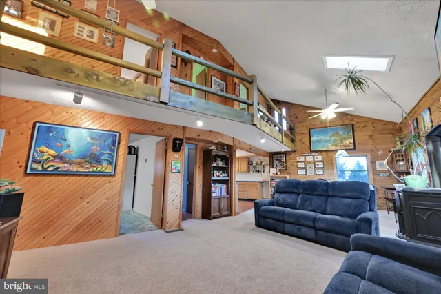 a living room with furniture a ceiling fan and a window