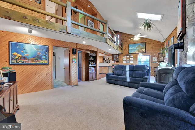 a living room with furniture a ceiling fan and a window