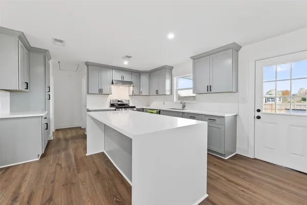 a view of a kitchen with furniture and wooden floor