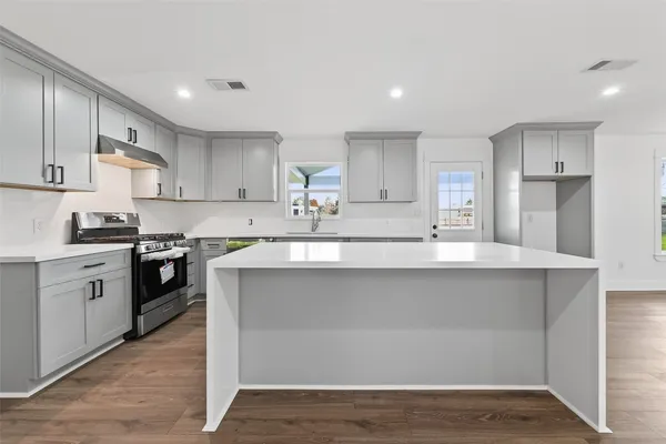 a kitchen with wooden floors and white appliances