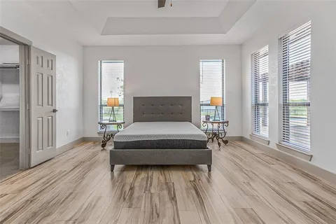 a bedroom with a bed and wooden floor