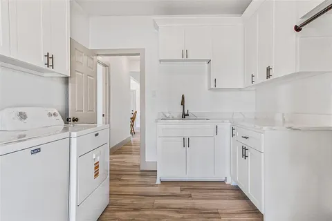 a kitchen with white cabinets and sink