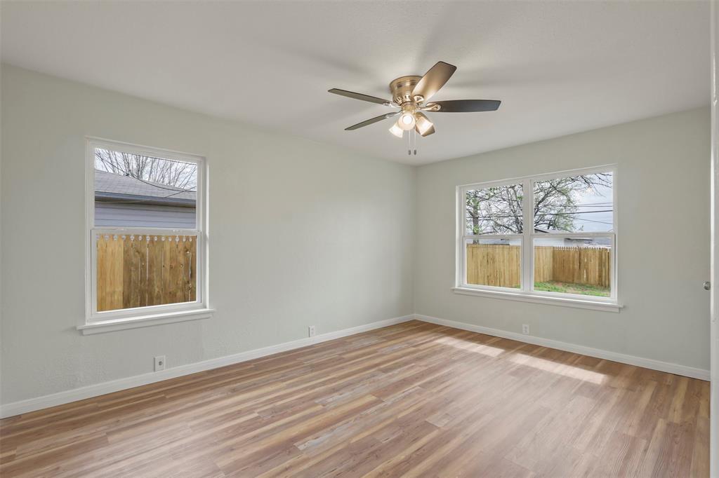 732 Bullock Street Denison, TX 75020 - Photo 13 of 29 a view of an empty room with a window and wooden floor