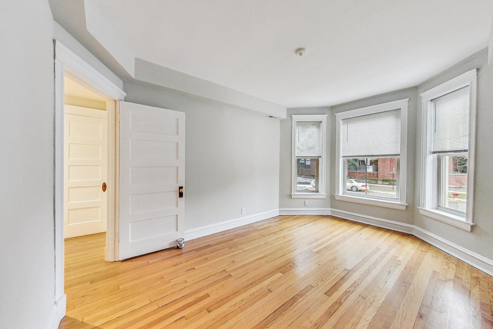 4000 North Hermitage Avenue, Unit 1 Chicago, IL 60613 - Photo 13 of 28 a view of an empty room with a window and wooden floor