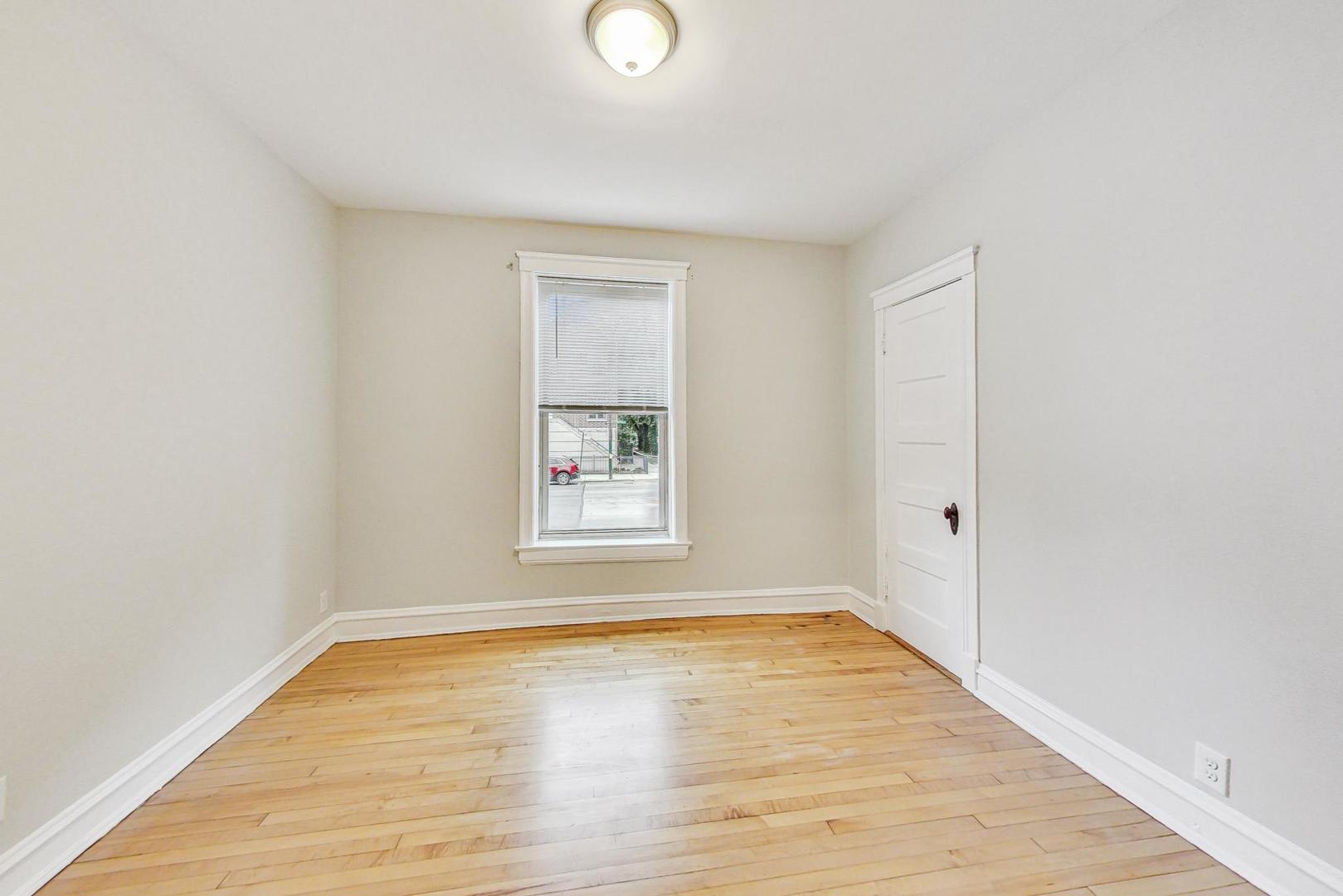 4000 North Hermitage Avenue, Unit 1 Chicago, IL 60613 - Photo 15 of 28 a view of an empty room with wooden floor and a window