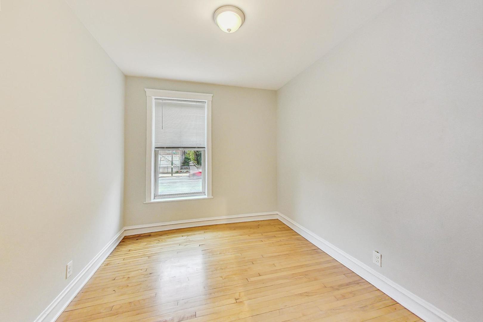 4000 North Hermitage Avenue, Unit 1 Chicago, IL 60613 - Photo 18 of 28 a view of an empty room with wooden floor and a window