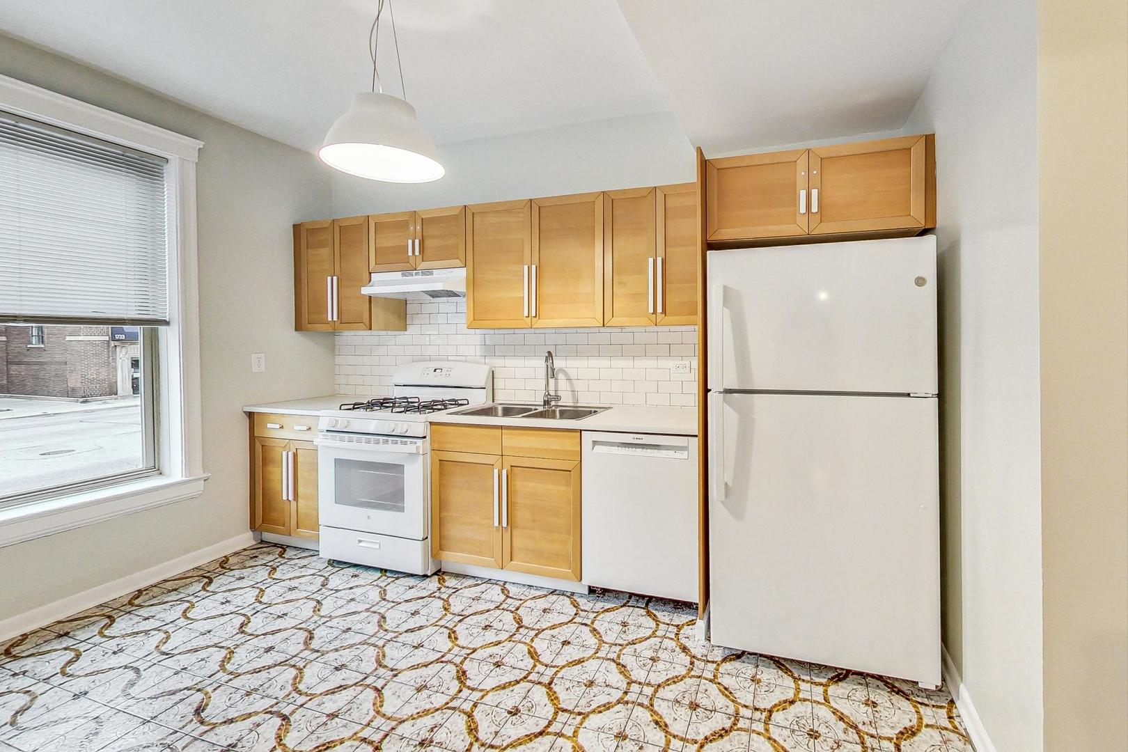 4000 North Hermitage Avenue, Unit 1 Chicago, IL 60613 - Photo 9 of 28 a kitchen with a refrigerator sink and cabinets