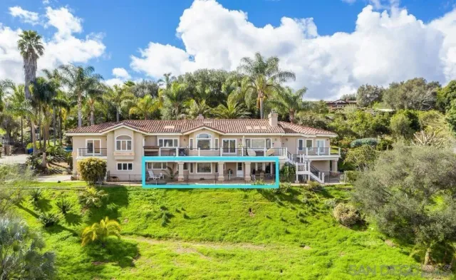 a front view of a house with garden and trees