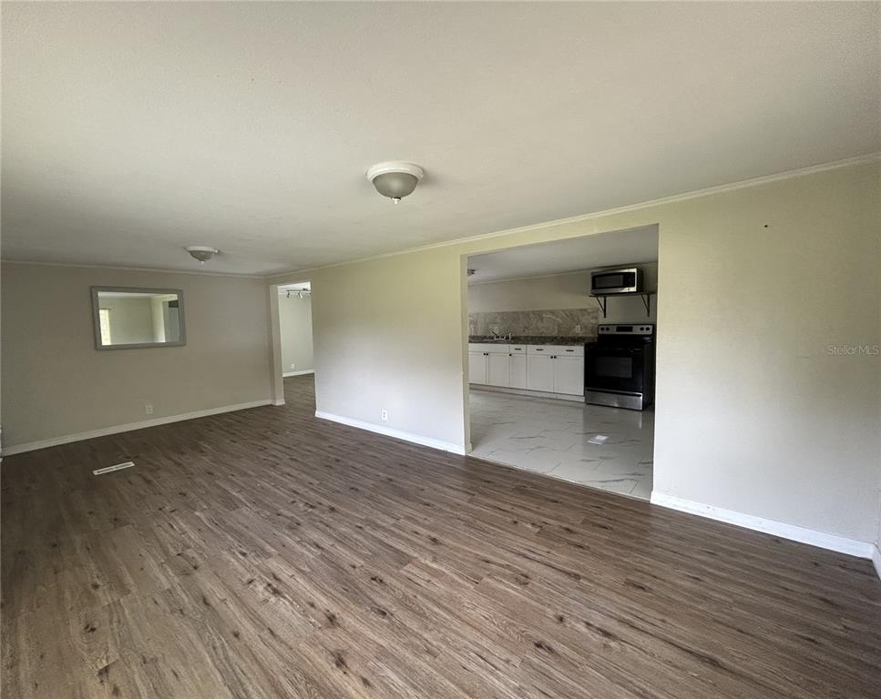 4265 North Beginning Path Crystal River, FL 34428 - Photo 4 of 18 a view of empty room with wooden floor and kitchen