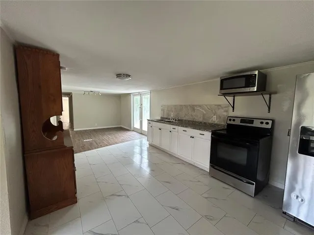 a kitchen with stainless steel appliances granite countertop a refrigerator and a stove top oven