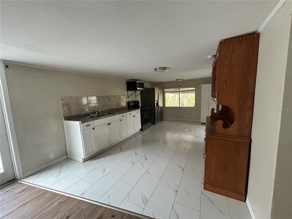 4265 North Beginning Path Crystal River, FL 34428 - Photo 7 of 18 a kitchen with granite countertop a refrigerator and a stove top oven