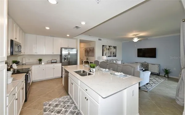 a room with a white countertops a stove and a flat screen tv