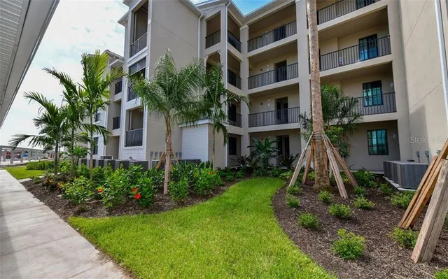 a front view of multi story residential apartment building with yard and green space