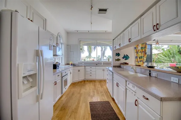 a kitchen with stainless steel appliances a white cabinets and a chandelier