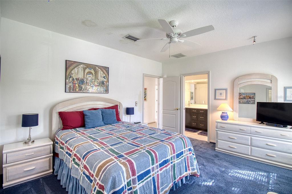 131 13th Street East Tierra Verde, FL 33715 - Photo 14 of 54 a spacious bedroom with a bed and a flat screen tv